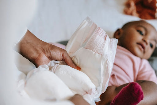 Black Mother changes baby’s diaper